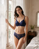 Navy floral lace bra and panty lingerie set, wire-free and lightly padded, worn by a model by a window